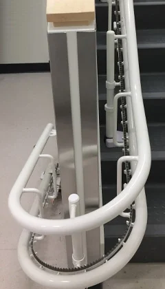 Close up shot of curved stairlift rail along staircase featuring gear mechanism.