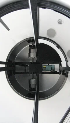 Interior view of a winding drum elevator, showing the drum mechanism inside a glass-enclosed shaft.