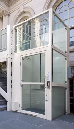 Luxury Vertical platform lift installed outdoors attached to a public building.