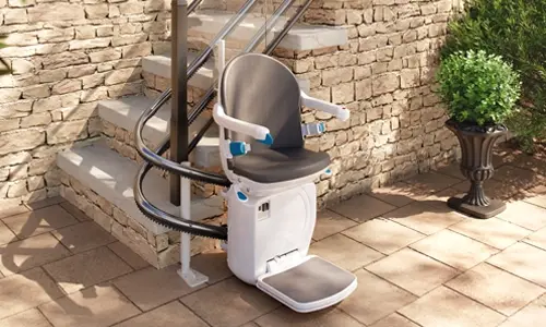A Handicare 4000 stairlift installed outdoors on a stone staircase.