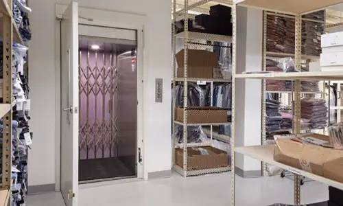 A Vertical Reciprocating Conveyor material lift in an apparel store.