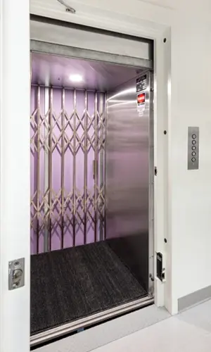 A vertical reciprocating conveyor that has a stainless steel interior and scissor gate.